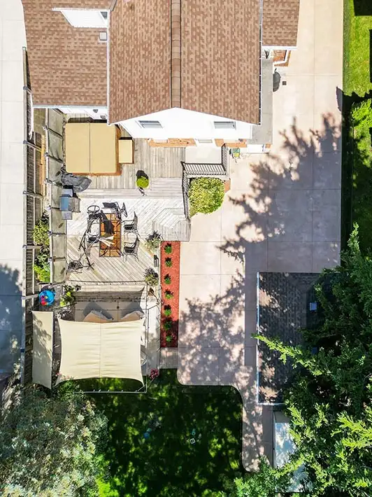Top-down view of a backyard concrete patio with steps, a hot tub, and two lounge areas