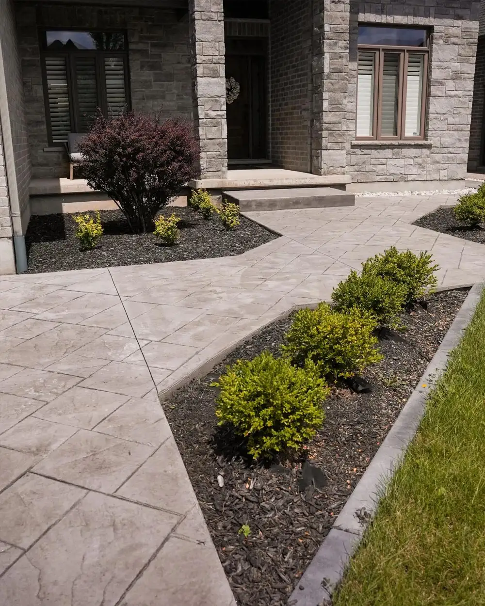 A stamped concrete walkway leading to a house entrance