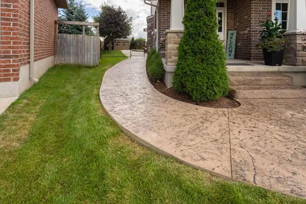 Concrete walkway that leads from the home entrance to the backyard