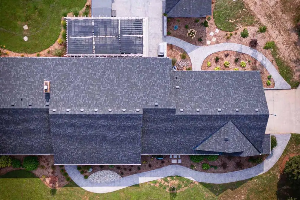 Top-down view of a concrete walkway going around 3 sides of a very large house